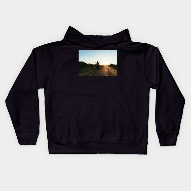 Silhouette of Boy Riding Bicycle at Sunset in Burmese Countryside Kids Hoodie by visualspectrum